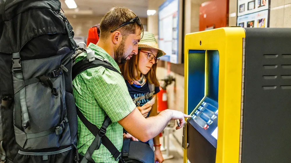 tourist with backpack withdraws money from the ATM